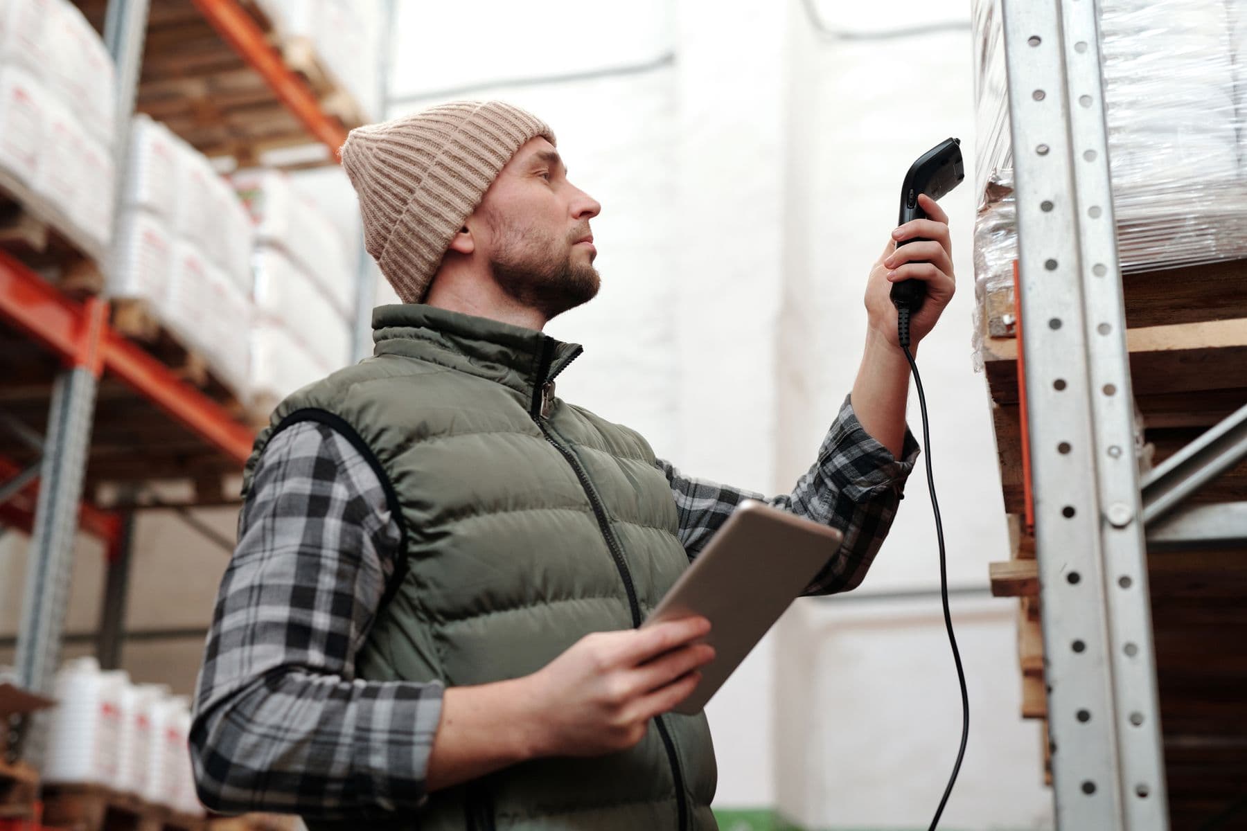 A logistics worker scanning palletized parcels in a warehouse